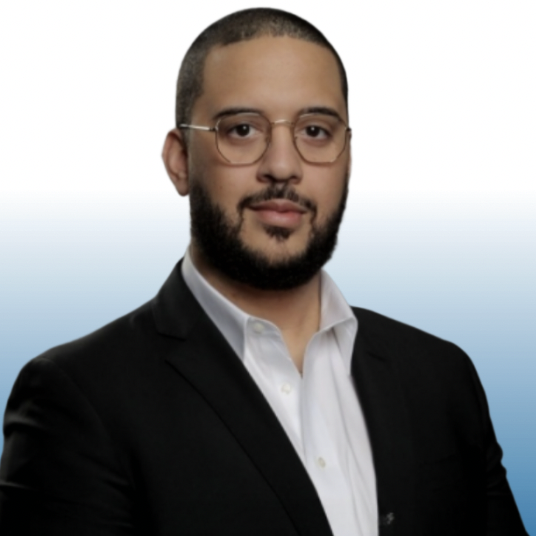 Professional headshot of an Equity team member wearing glasses and a black blazer